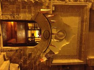 a clock on a wall with a mirror at Zinciriye Hotel in Mardin