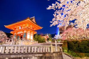 an orange building with a fence andakura trees at Hotel CoCoDe Plus in Osaka