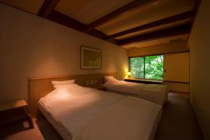 a bedroom with two beds and a window at Fujiiso in Takayama +74 photos