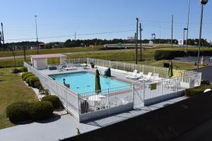 a pool with a swimming pool and a tennis court at Super 8 by Wyndham Tifton in Tifton