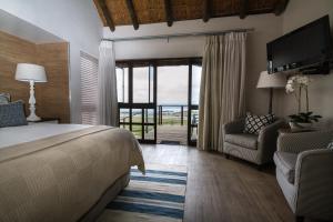 1 dormitorio con 1 cama, 1 sofá y 1 silla en Little Rock Guesthouse, en Jongensfontein