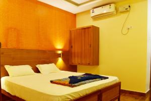 a bedroom with a bed with a wooden headboard at Hotel Ganga Tamilnadu in Nāgercoil