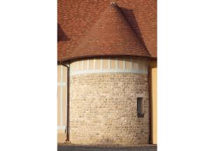 a large brick building with a brown roof at La porte bleue in Trouville-sur-Mer