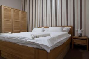 una camera da letto con un grande letto con lenzuola e cuscini bianchi di Villa Cafe a Krnov