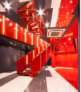 a red staircase in a room with lights at Klub Hotel Bangkok in Bangkok