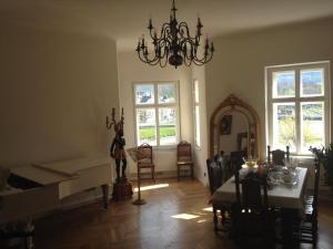 ein Wohnzimmer mit einem Klavier, einem Tisch und einem Spiegel in der Unterkunft Sarah's Altstadt Oase Salzburg in Salzburg