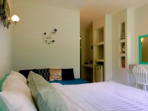 1 dormitorio con 1 cama y 1 silla en Sense of Yanui, en Nai Harn Beach