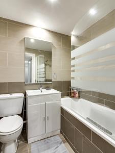 パリにあるウェルキーズ アパートメント パリ リヴォリのバスルーム(トイレ、洗面台、バスタブ付)