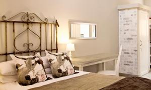 a bedroom with a bed with pillows and a table at Pumpkin Tree Guesthouse in Middelburg