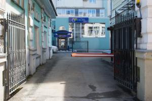 an empty alley with gates in front of a building at Hotel Eva in Perm