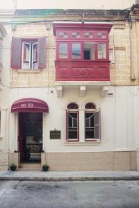 un edificio con una ventana roja en el lateral. en Granny's Inn Hostel, en Sliema