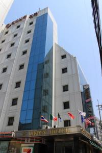 a tall white building with flags in front of it at Insadong Crown Hotel in Seoul