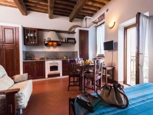 ein Wohnzimmer mit einem Tisch und einer Küche in der Unterkunft Country House il Ciliegio in Roccatederighi