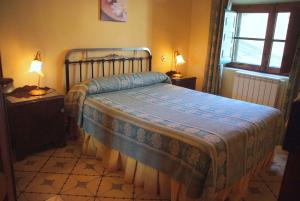 1 dormitorio con 1 cama, 2 lámparas y ventana en Casa Rural Flor, en Vadocondes