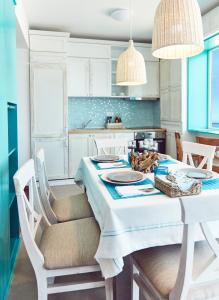 a white kitchen with a table and chairs at Holidays Casa del Sole Mamaia Nord in Mamaia Sat/Năvodari