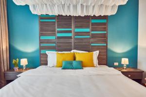 a bedroom with a large bed with yellow and blue walls at Holidays Casa del Sole Mamaia Nord in Mamaia Sat/Năvodari
