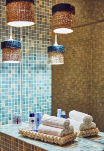 a bathroom with a sink with towels and lights at Holidays Casa del Sole Mamaia Nord in Mamaia Sat/Năvodari