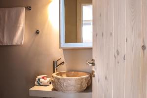 a bathroom with a large bowl sink on a counter at Camara Homes in Andros