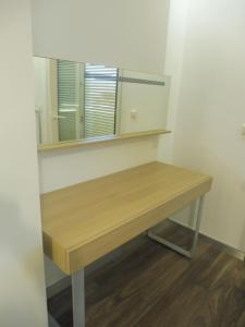 a dressing table with a mirror on a wall at Azur Apartman in Velence