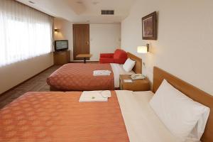 Postel nebo postele na pokoji v ubytování Kumegawa Wing Hotel