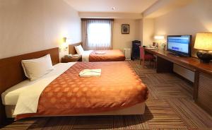 Postel nebo postele na pokoji v ubytování Kumegawa Wing Hotel