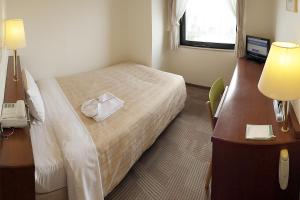 Postel nebo postele na pokoji v ubytování Kumegawa Wing Hotel