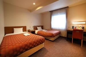 Postel nebo postele na pokoji v ubytování Kumegawa Wing Hotel