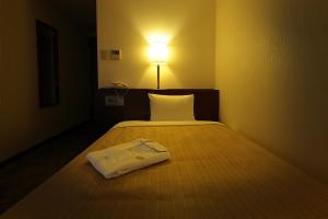 Postel nebo postele na pokoji v ubytování Kumegawa Wing Hotel