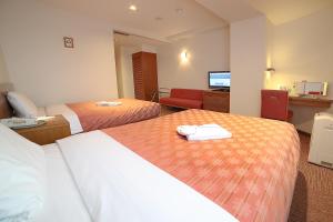 Postel nebo postele na pokoji v ubytování Kumegawa Wing Hotel