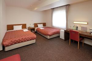 Postel nebo postele na pokoji v ubytování Kumegawa Wing Hotel