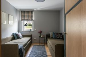 salon z kanapą i oknem w obiekcie Close to nature - Nida Apartments w mieście Nida