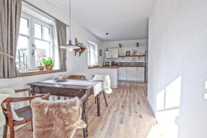 uma cozinha e sala de jantar com uma mesa de madeira em Ferienwohnung Eifelrausch em Berenbach