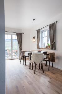 uma sala de jantar com uma mesa e cadeiras e uma janela em Ferienwohnung Eifelrausch em Berenbach