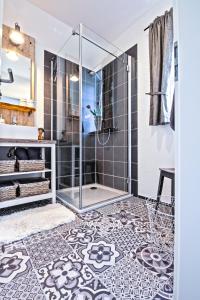 uma casa de banho com um chuveiro com azulejos pretos e brancos em Ferienwohnung Eifelrausch em Berenbach