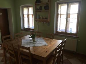 a dining room table with a vase of flowers on it at Rekreační dům u Marušky in Božanov