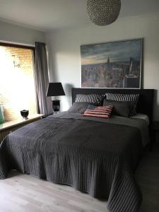 ein Schlafzimmer mit einem großen Bett und einem Gemälde an der Wand in der Unterkunft 1-Zimmer-Appartment Miami in Timmendorfer Strand