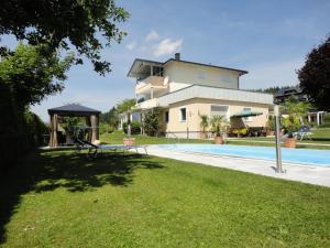 a villa with a swimming pool and a house at Ferienparadies Goritschnig in Velden am Wörthersee
