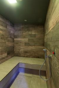 Una ducha en una habitación con paredes de madera. en Hotel Le Palme en Dormelletto