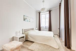 a white bedroom with a bed and a window at SutkiMinsk Apartment Centre in Minsk