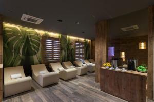 a waiting room with white chairs and a waiting desk at Hotel Le Palme in Dormelletto