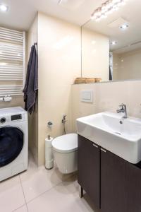 a bathroom with a sink and a washing machine at Baranova Apartments in Prague