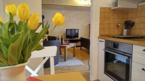 una cocina con un jarrón de tulipanes amarillos en Maifeld-Fewo Rhapsodie, en Kerben