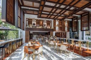 a restaurant with tables and chairs and a bar at 137 Pillars Suites Bangkok in Bangkok