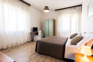 Schlafzimmer mit einem Bett und einem Schreibtisch mit einem Computer in der Unterkunft Hotel Antagos in Montesilvano