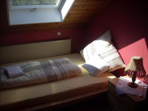 a bedroom with a bed with a window and a lamp at Ferienwohnung Lahntal/Taunus in Hochelheim