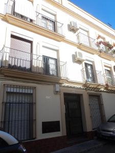 un edificio de apartamentos blanco con balcones y puertas en Apartamento Centro Jerez Campana, en Jerez de la Frontera