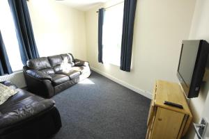 a living room with a couch and a television at 55A Derbyshire Lane in Sheffield