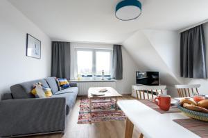 ein Wohnzimmer mit einem Sofa und einem Tisch in der Unterkunft Haus am Meer-Ferienwohnungen Sylt in Hörnum