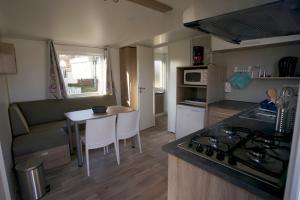 a small kitchen and living room with a table and a couch at Camping Panorama in Bourscheid