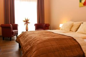 A bed or beds in a room at Maya Panzio-Rezidencia